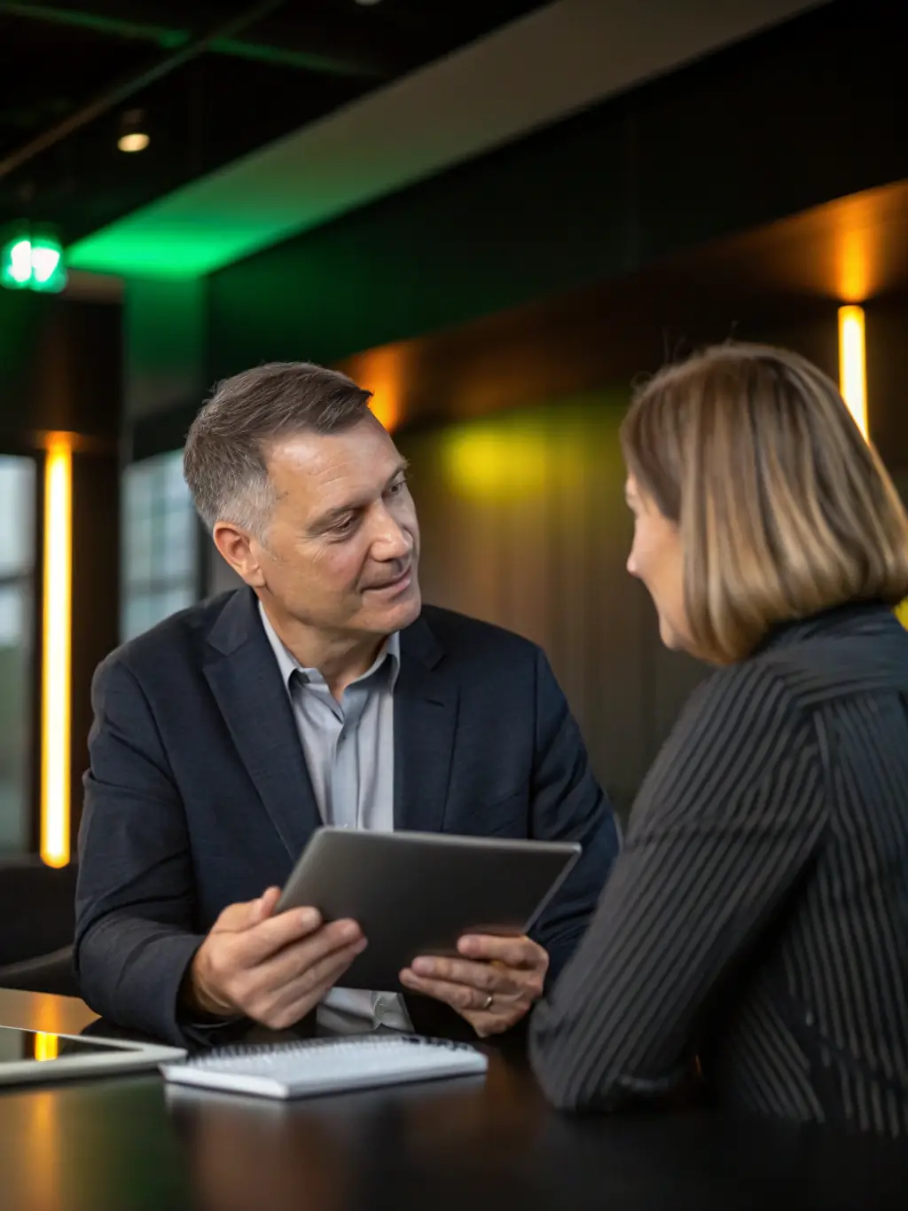 A photo of a Nozhian IT consultant directly interacting with a client, explaining complex IT solutions in a simple and understandable manner, fostering a collaborative environment.